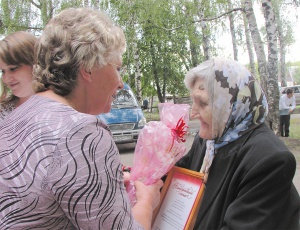 Заместитель главы Сеченовской сельской администрации Л.А. Линькова вручает Благодарственное письмо старейшей жительнице поселка Е.В. Зенкиной 