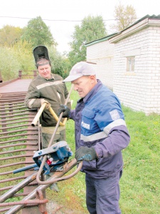 Газоэлектросварщик А. Морозов и водитель М.И. Бочкарев делают заготовки труб для газификации дома в В.Талызине